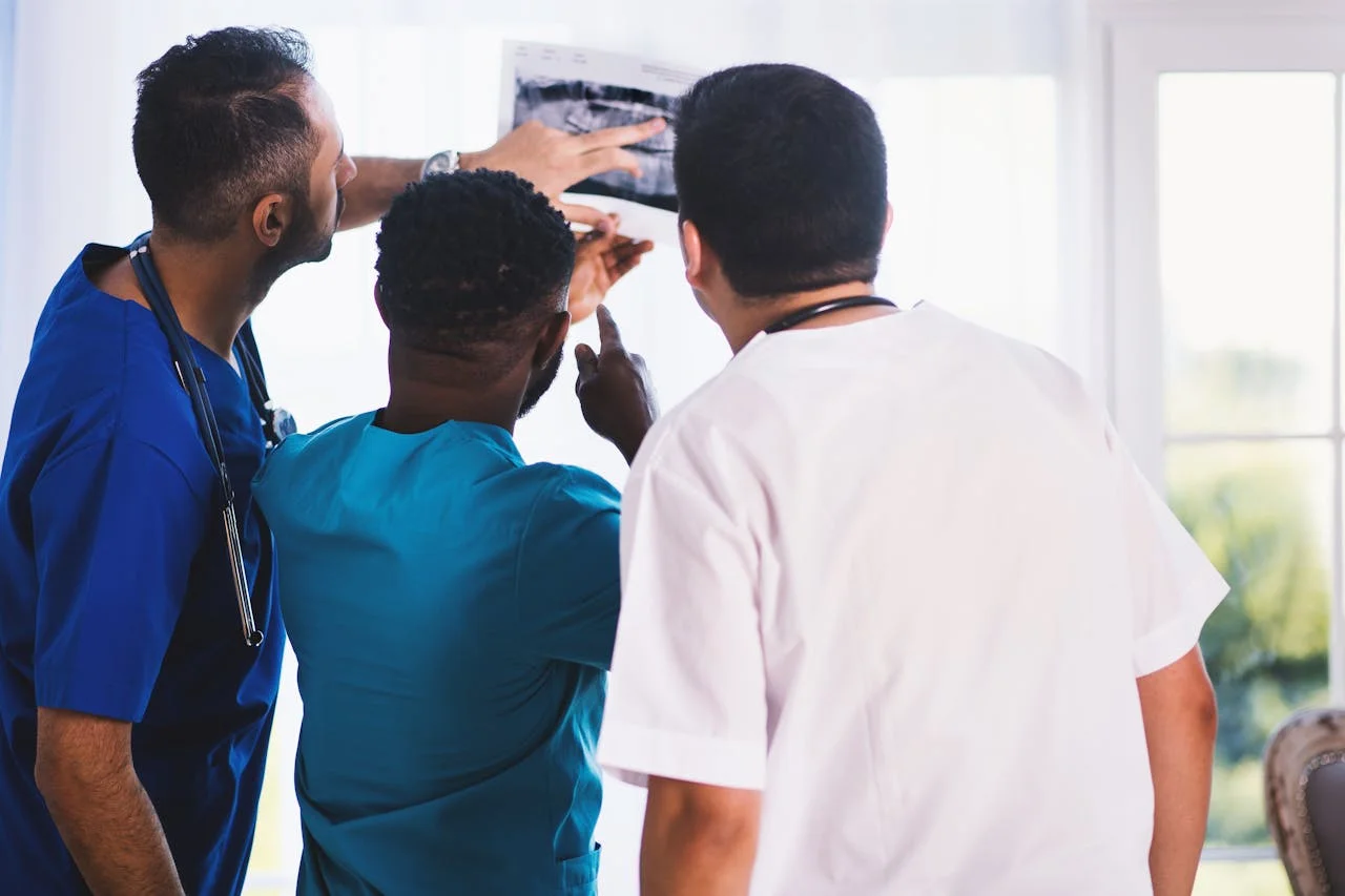 Drei medizinische Fachkräfte besprechen ein frühes Ultraschallbild und planen die nächsten diagnostischen Schritte rund um Zyklus und Kinderwunsch