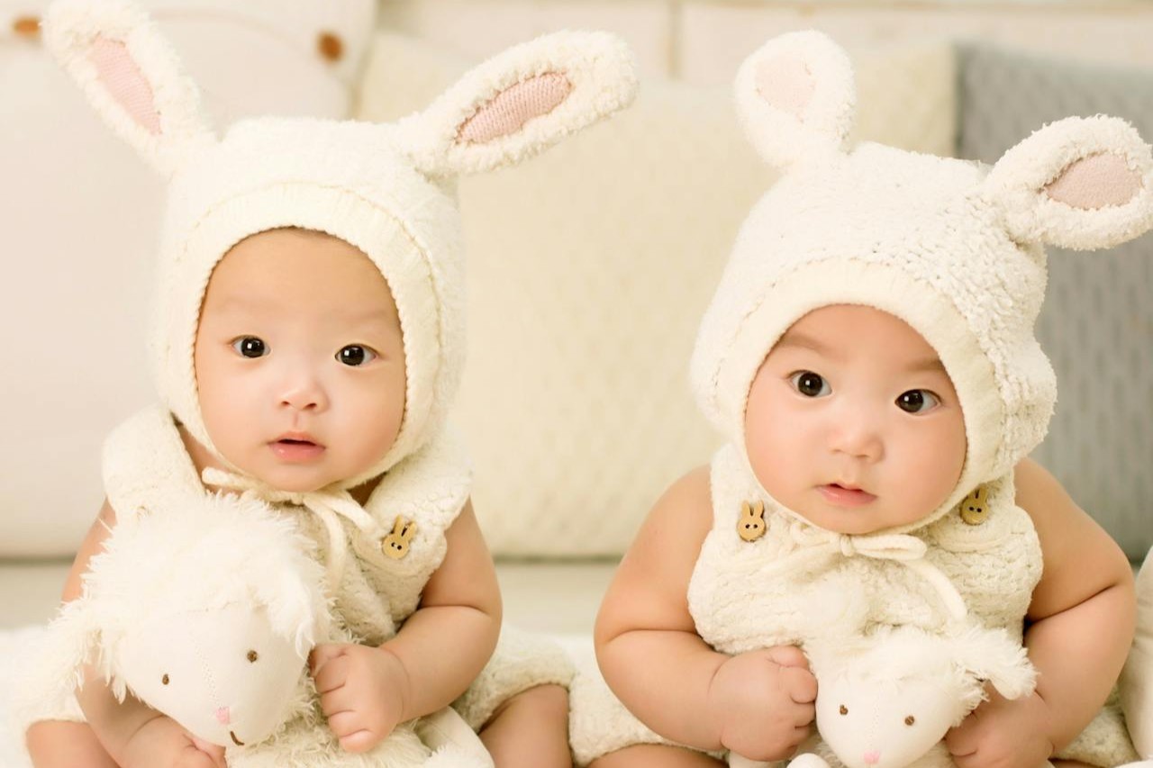Two pairs of baby shoes symbolizing twins and other multiple pregnancies