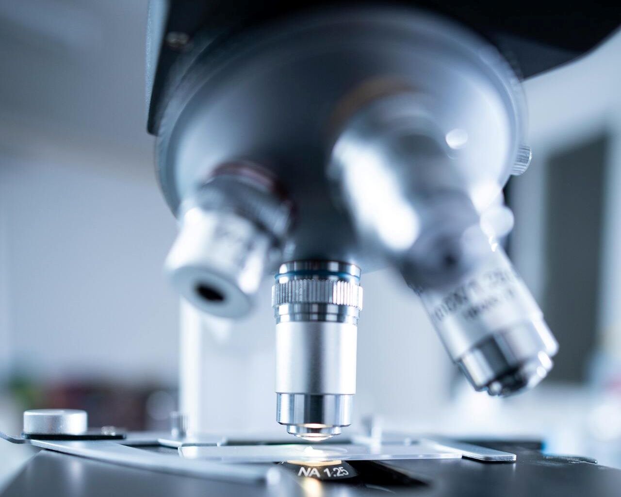 Técnica en laboratorio de andrología analiza una muestra de eyaculado con microscopio