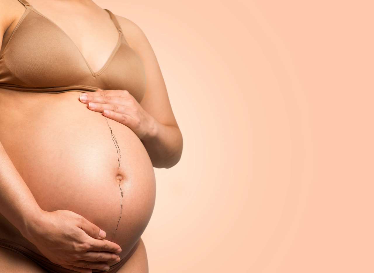 Gravid person med tydligt synlig linea nigra på magen