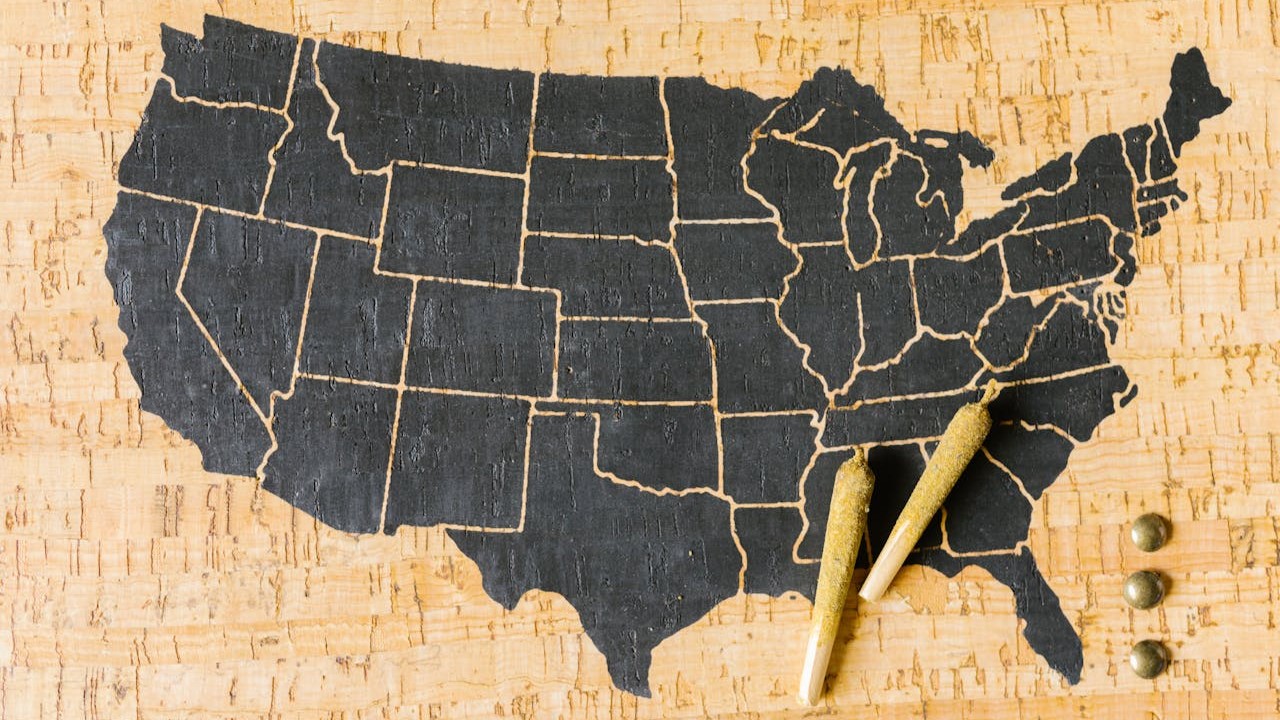 Hai cha mẹ đồng nuôi dạy con xem một kế hoạch nuôi dạy bằng văn bản bên cạnh bản đồ Mỹ và một cuốn lịch